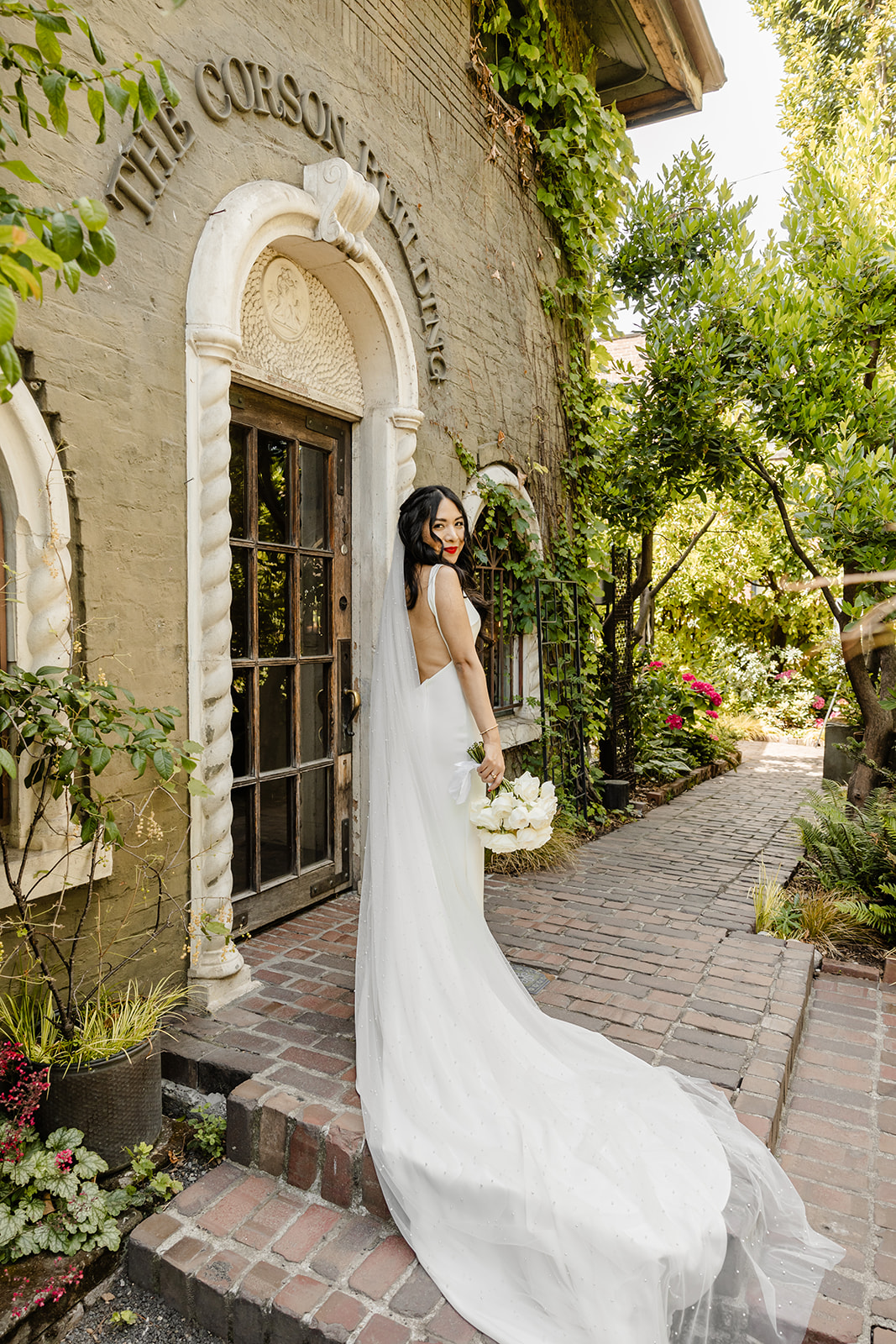 bride stands in front of the corson building