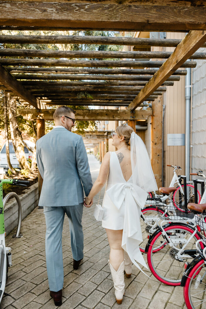 bride and groom walk down city street