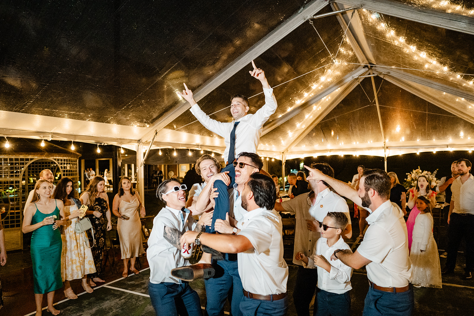 groom being lifted by groomsmen on reception dance floor under tent wedding rain plan ideas washington wedding photographer