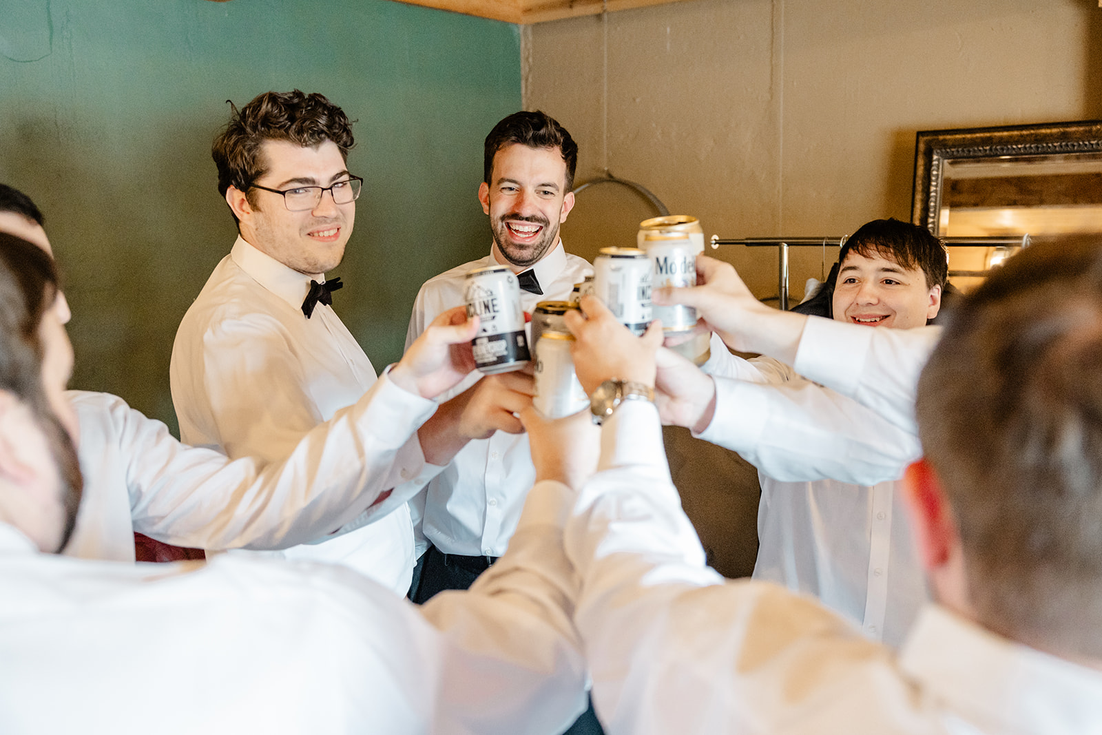 groom cheers drinks with his groomsmen