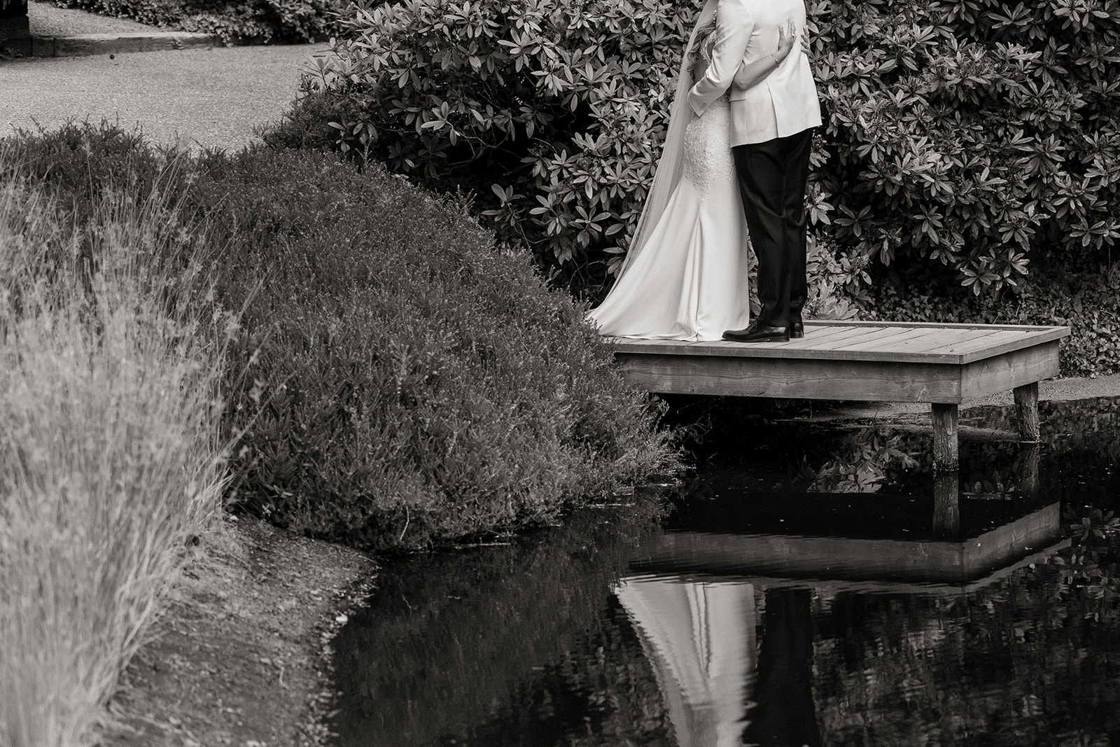 bride and groom embrace on bridge