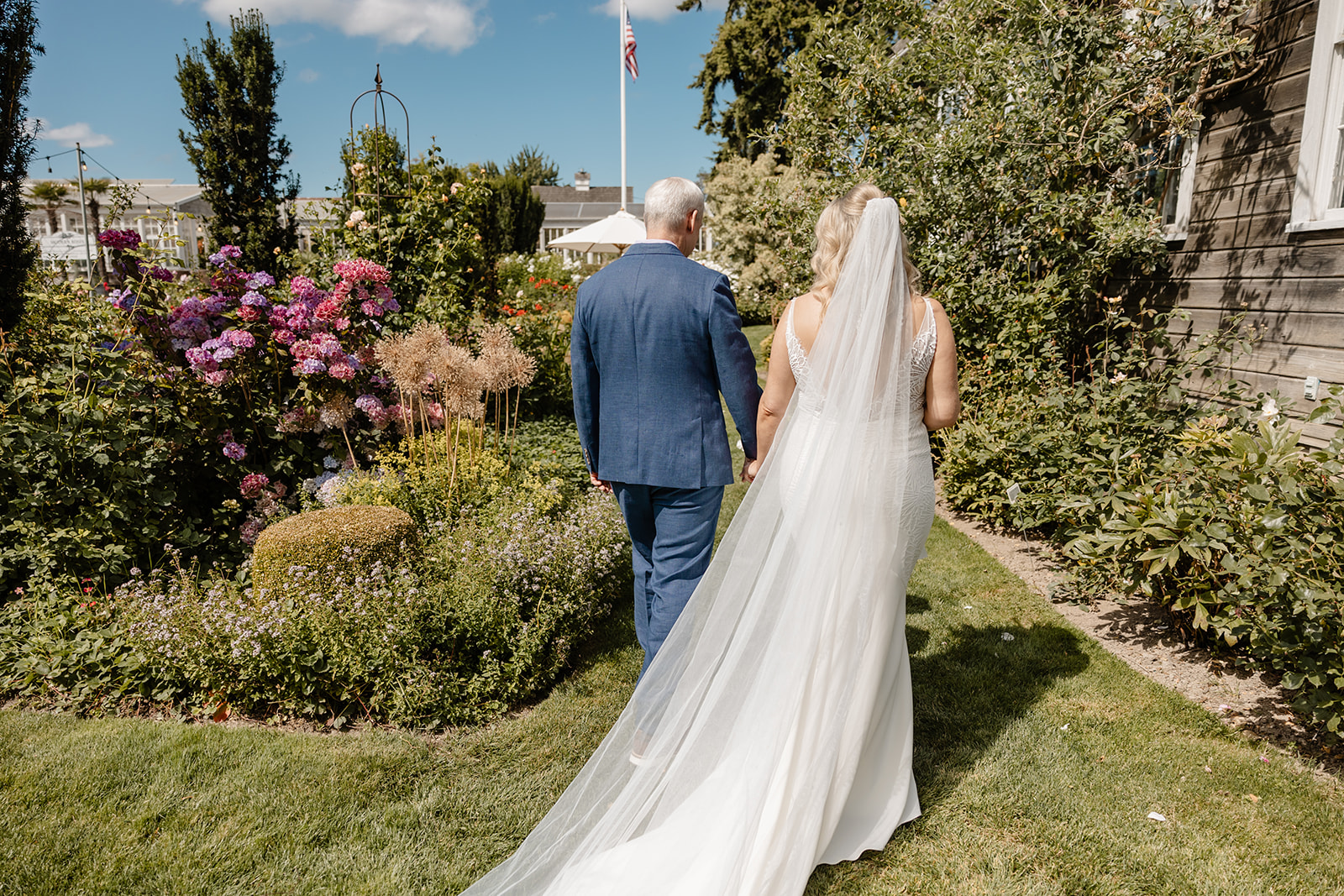 bride and groom walk through garden