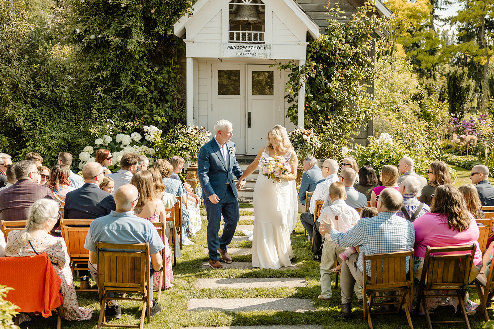 bride and groom walk up aisle at christianson's nursery ceremony