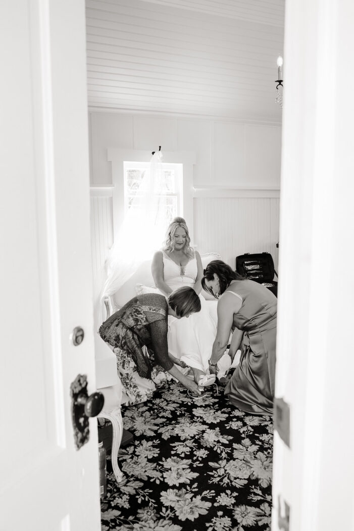 girls help bride get dressed