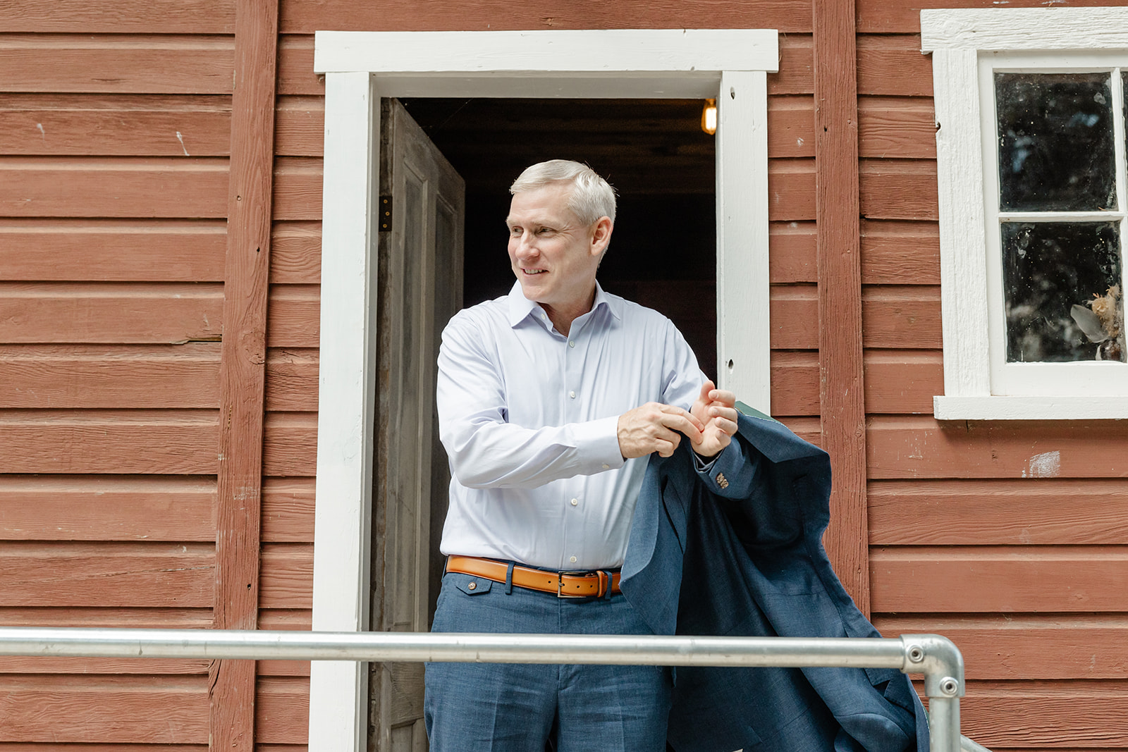 groom putting jacket on