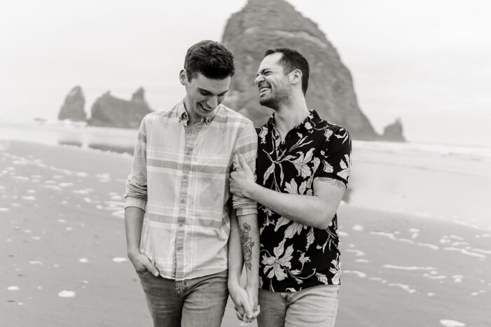 two men posing together on oregon coast beach