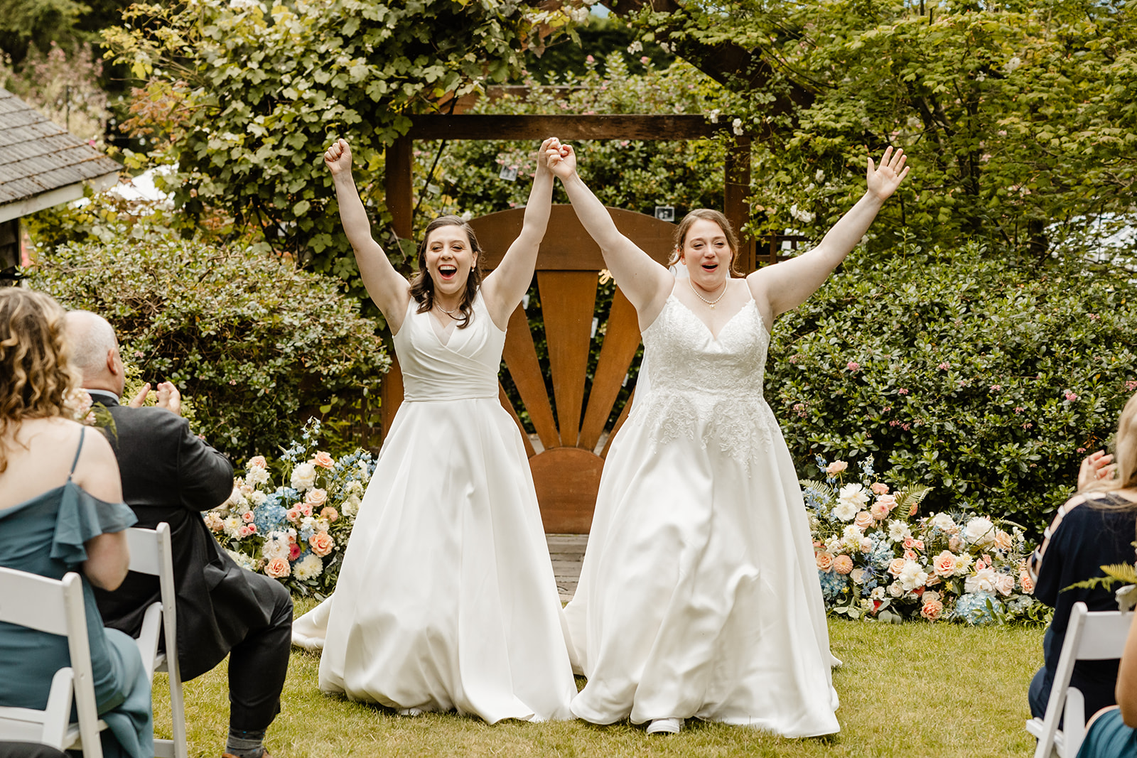 brides celebrate as they walk back up aisle