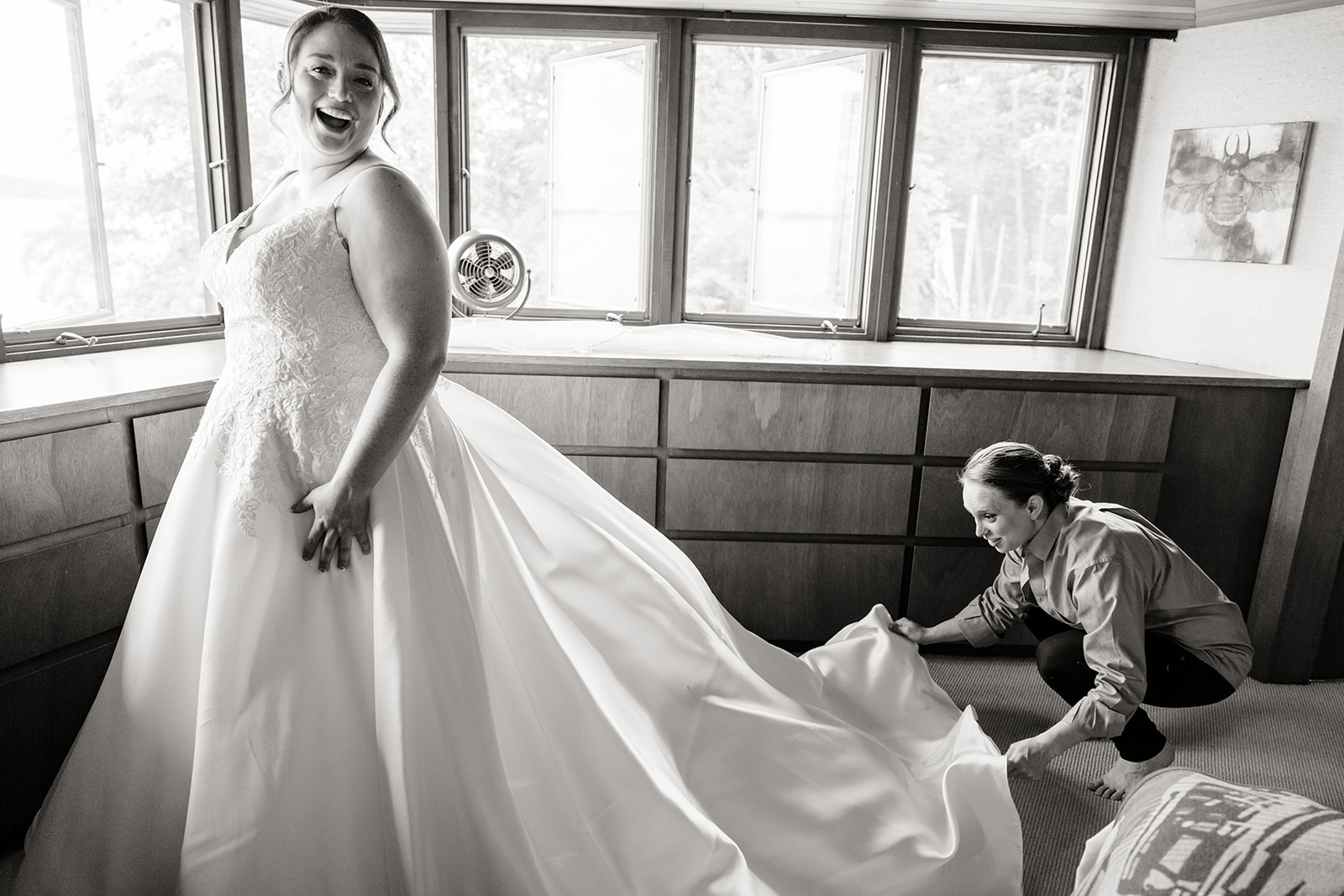 woman fluffs brides dress