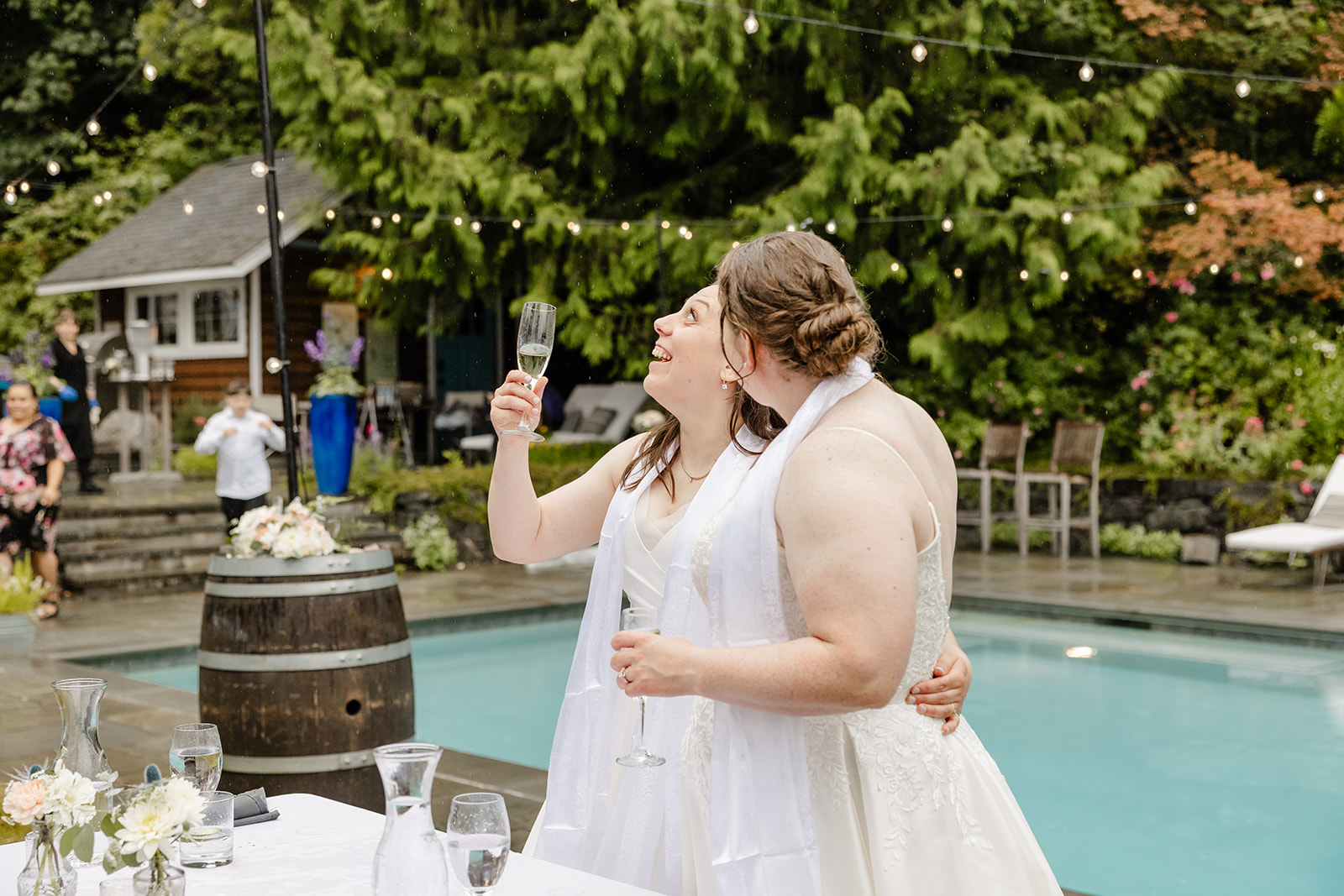 brides laughing and standing in rain