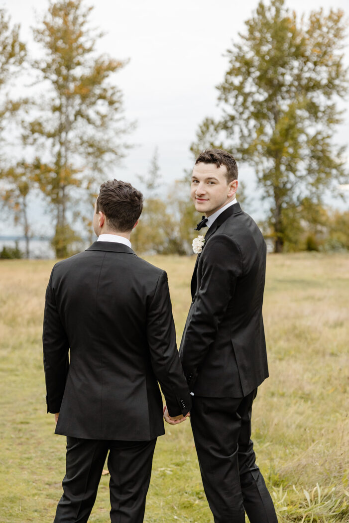 grooms holding hands and one looking