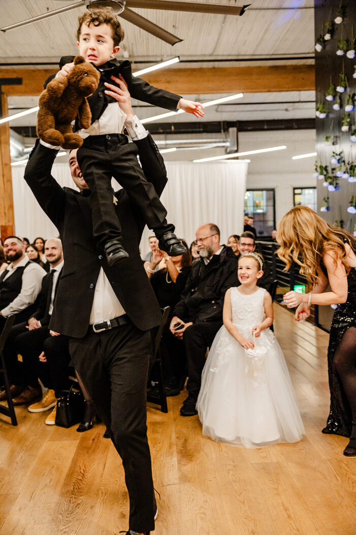 groom lifts ring bearer into air