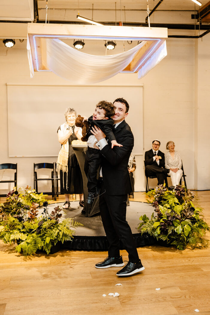 groom holds struggling ring bearer