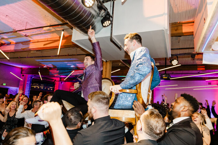 grooms on chairs at reception at block 41