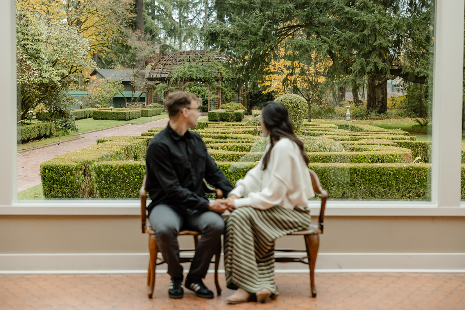 couple sits in front of window looking out at lakewold gardens