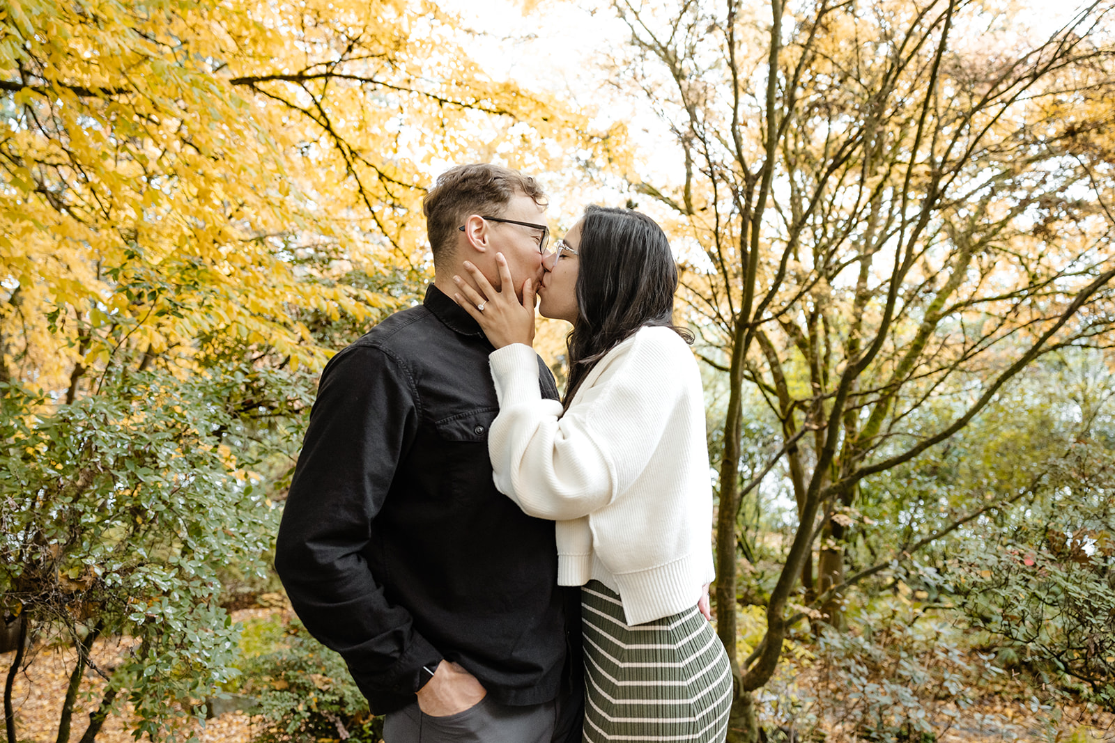couple kisses in front of autumn colors