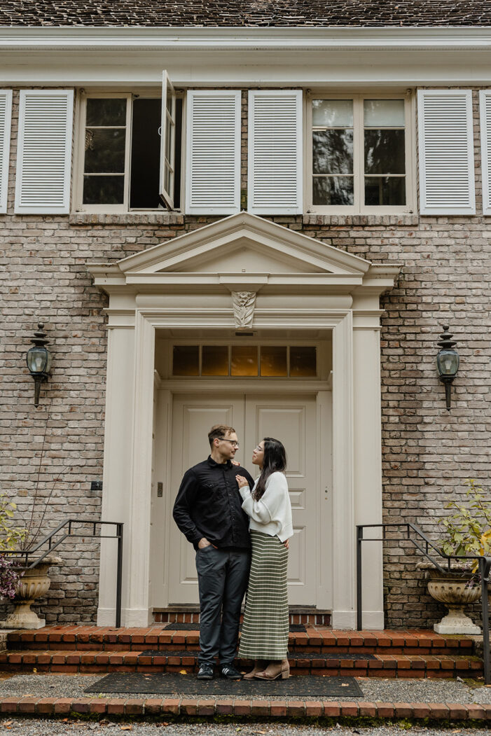 couple snuggles in front of lakewold gardens building