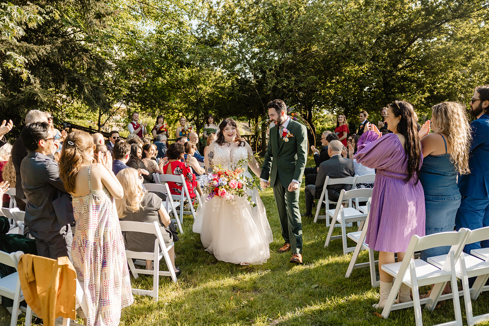 bride and groom smiling as they walk up aisle