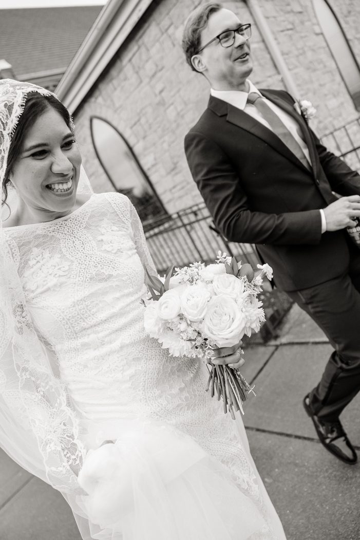 couple running together in the rain leaving their wedding ceremony rain wedding photos