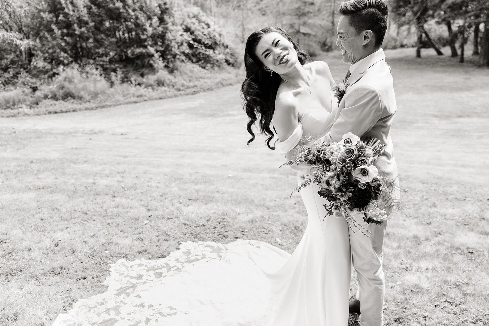 bride laughs while groom holds her