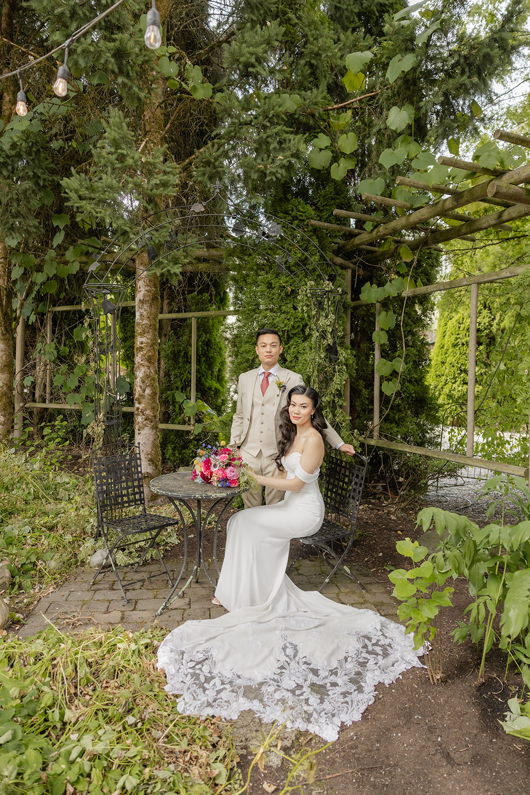 bride and groom sit together in garden