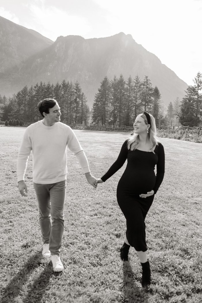 couple walks through field during maternity shoot