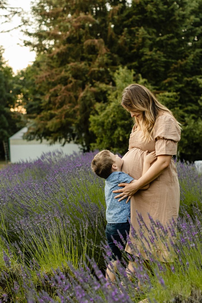 mom looks down at son in lavender field