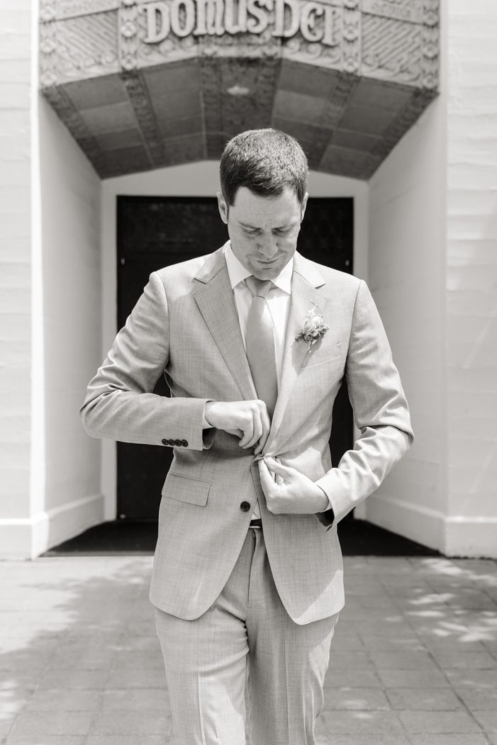 groom buttoning jacket