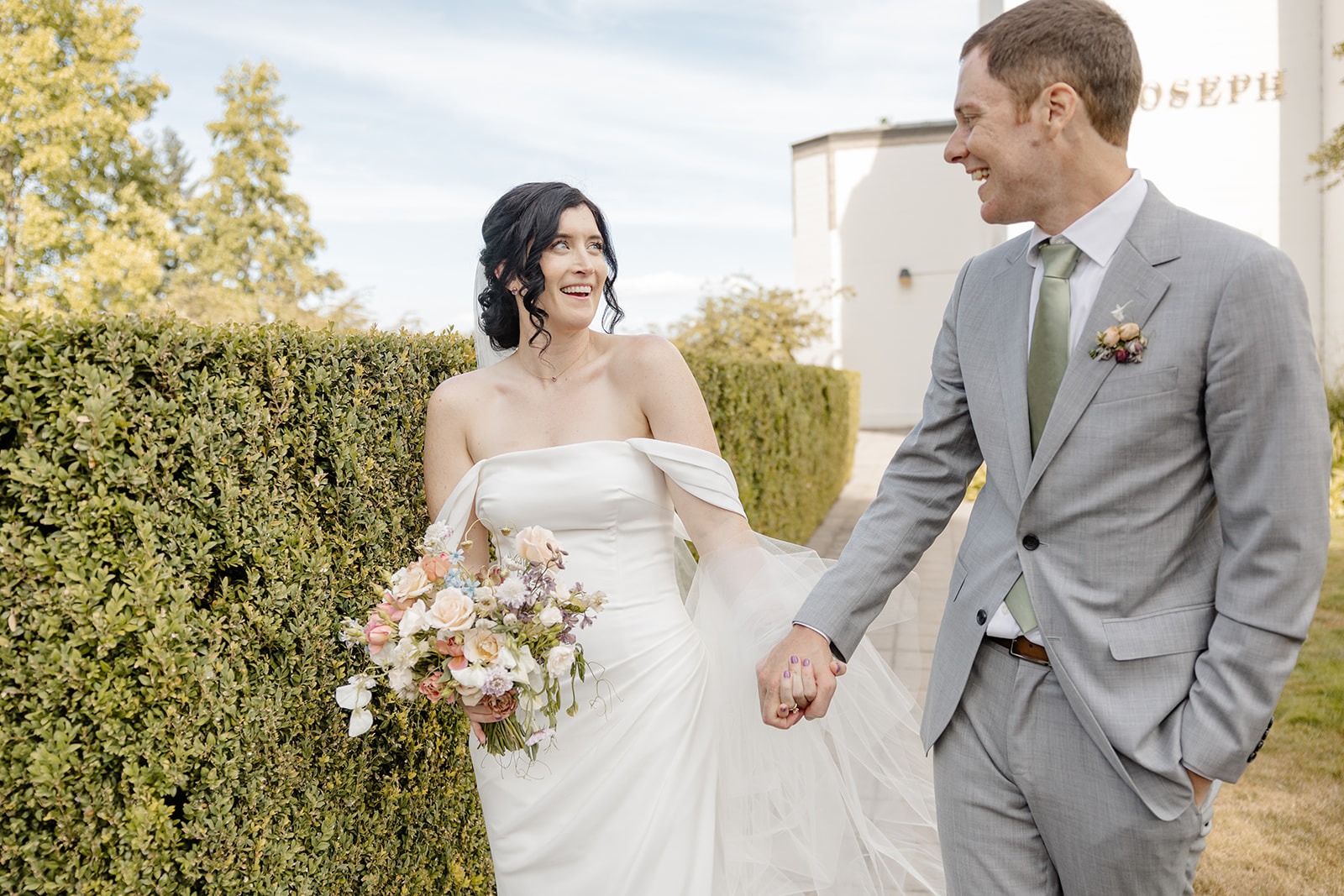bride and groom walking and smiling at each other