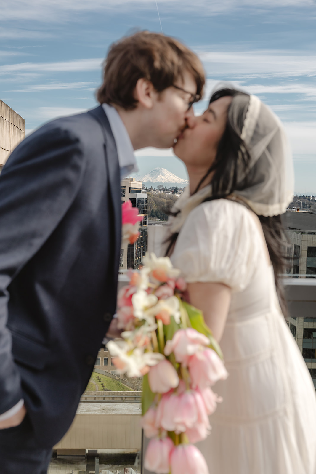couple kiss with mount rainier in the background municipal court of Seattle photographer