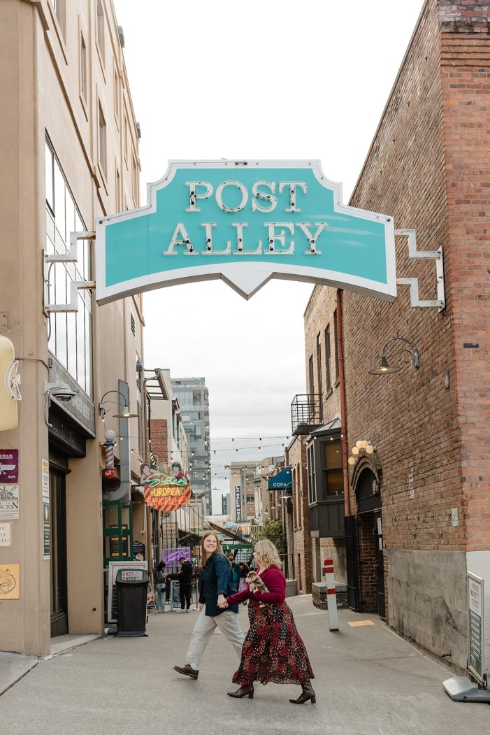 couple walks under the "post alley" sign
