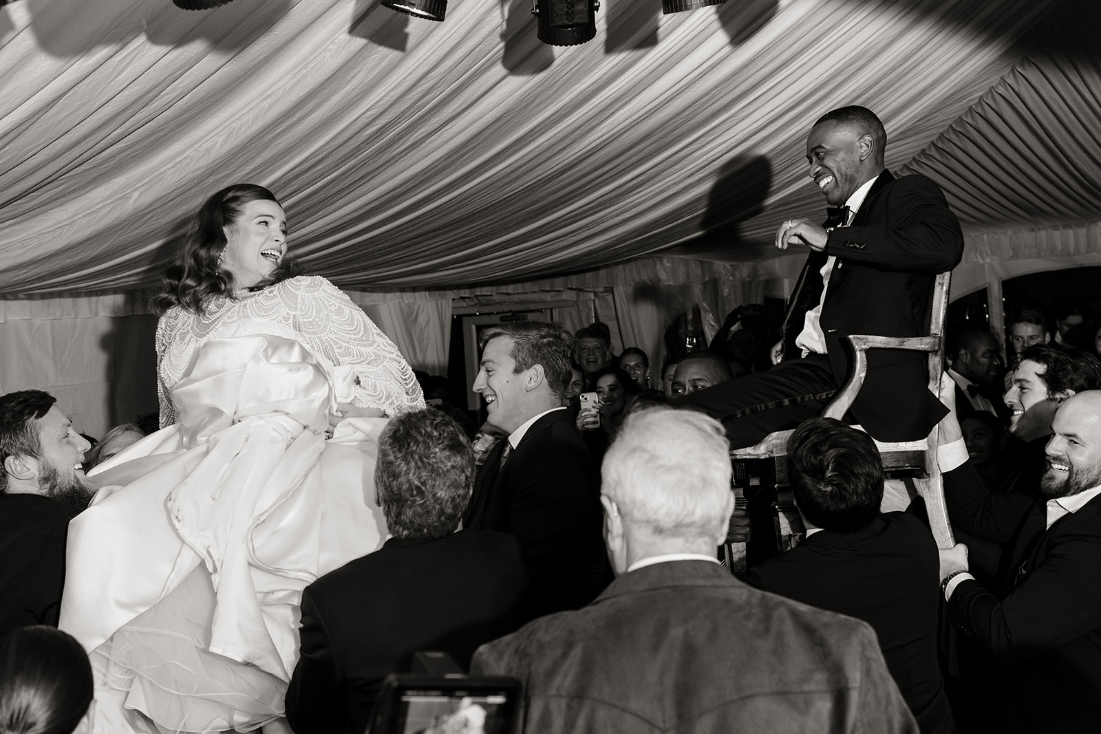 bride and groom up on chairs on dance floor