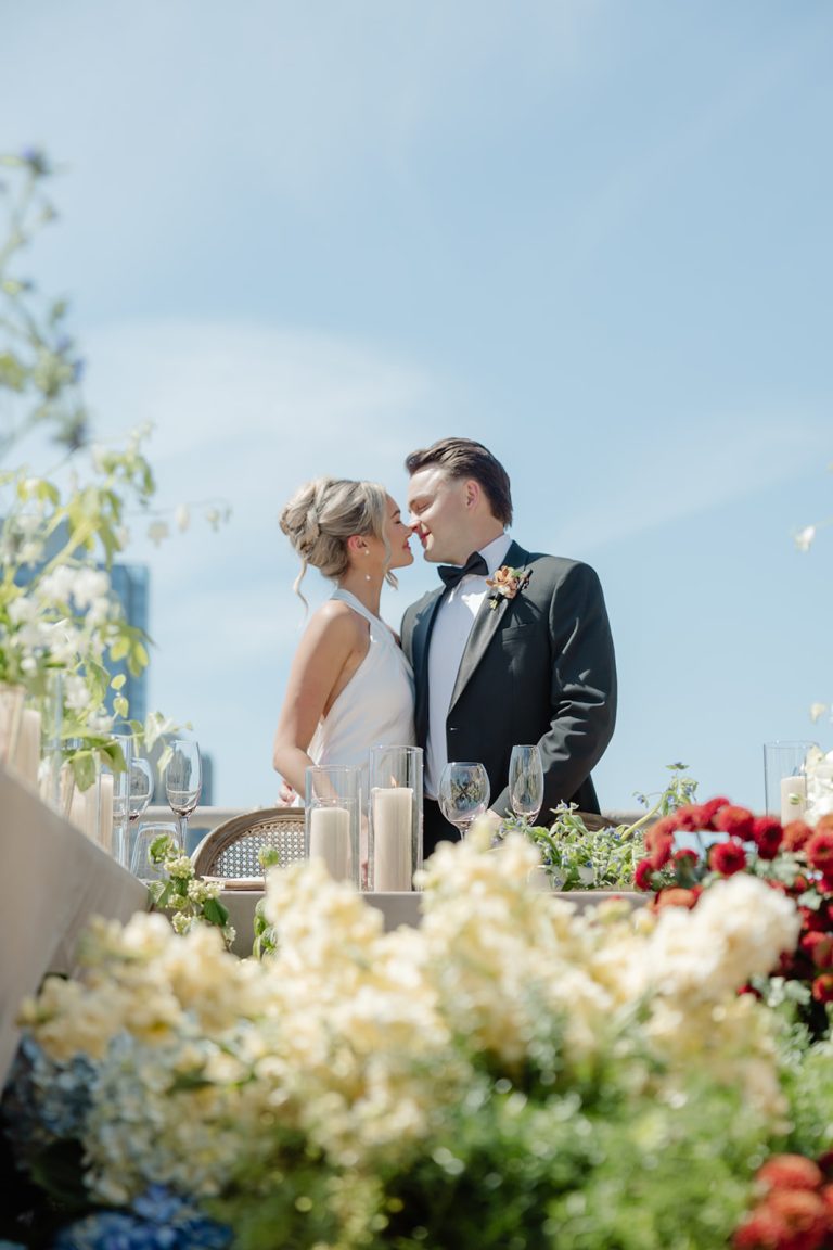 bride and groom beyond a mass of flowers