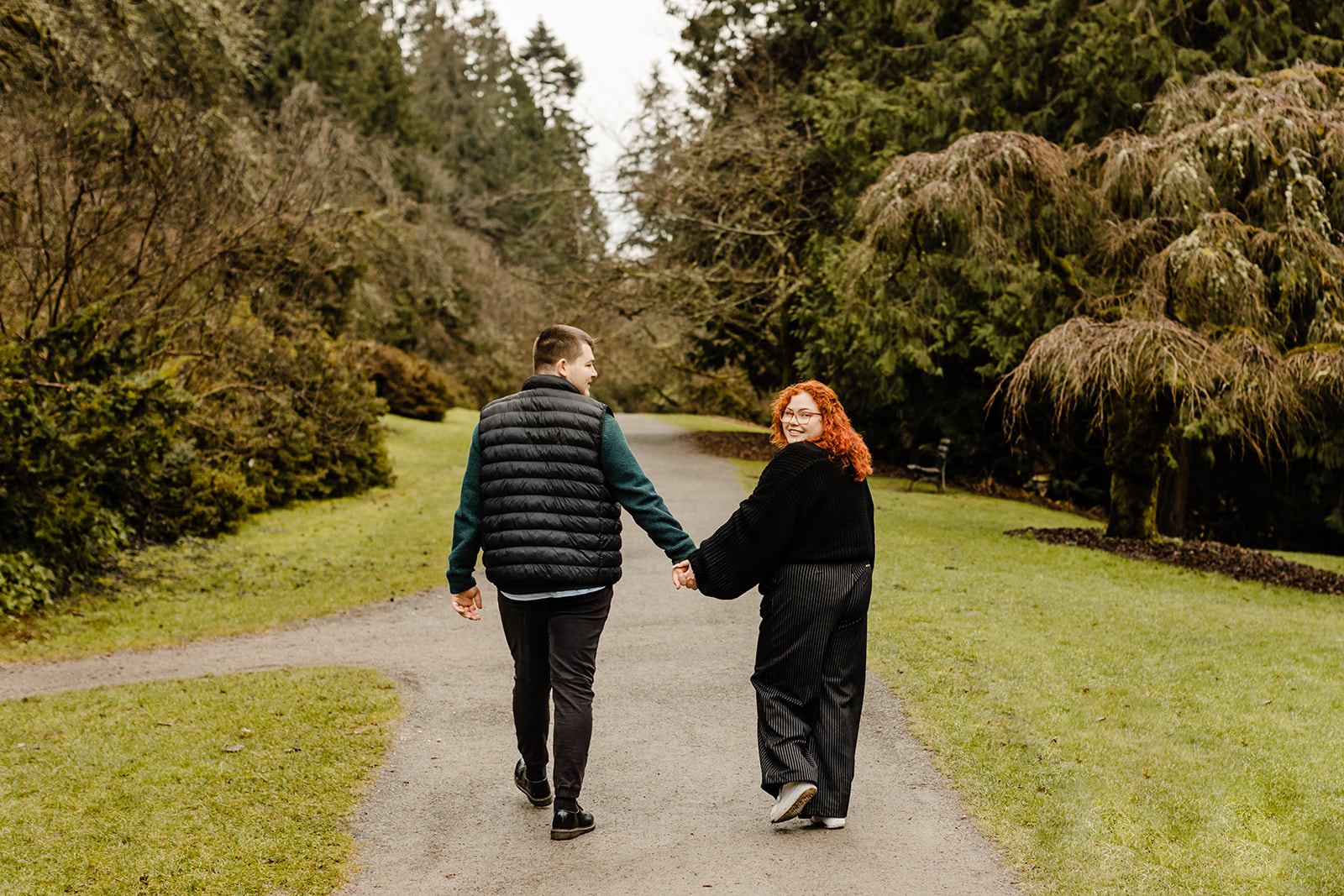 man and woman walk through park