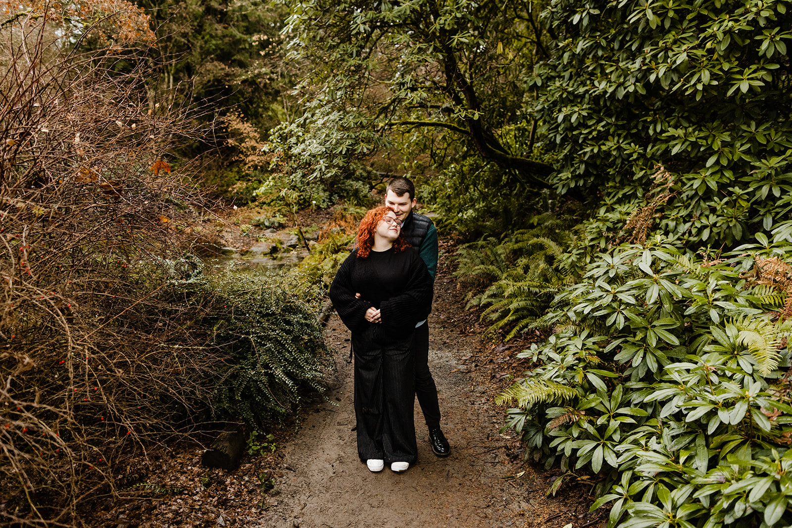 man and woman embrace in park