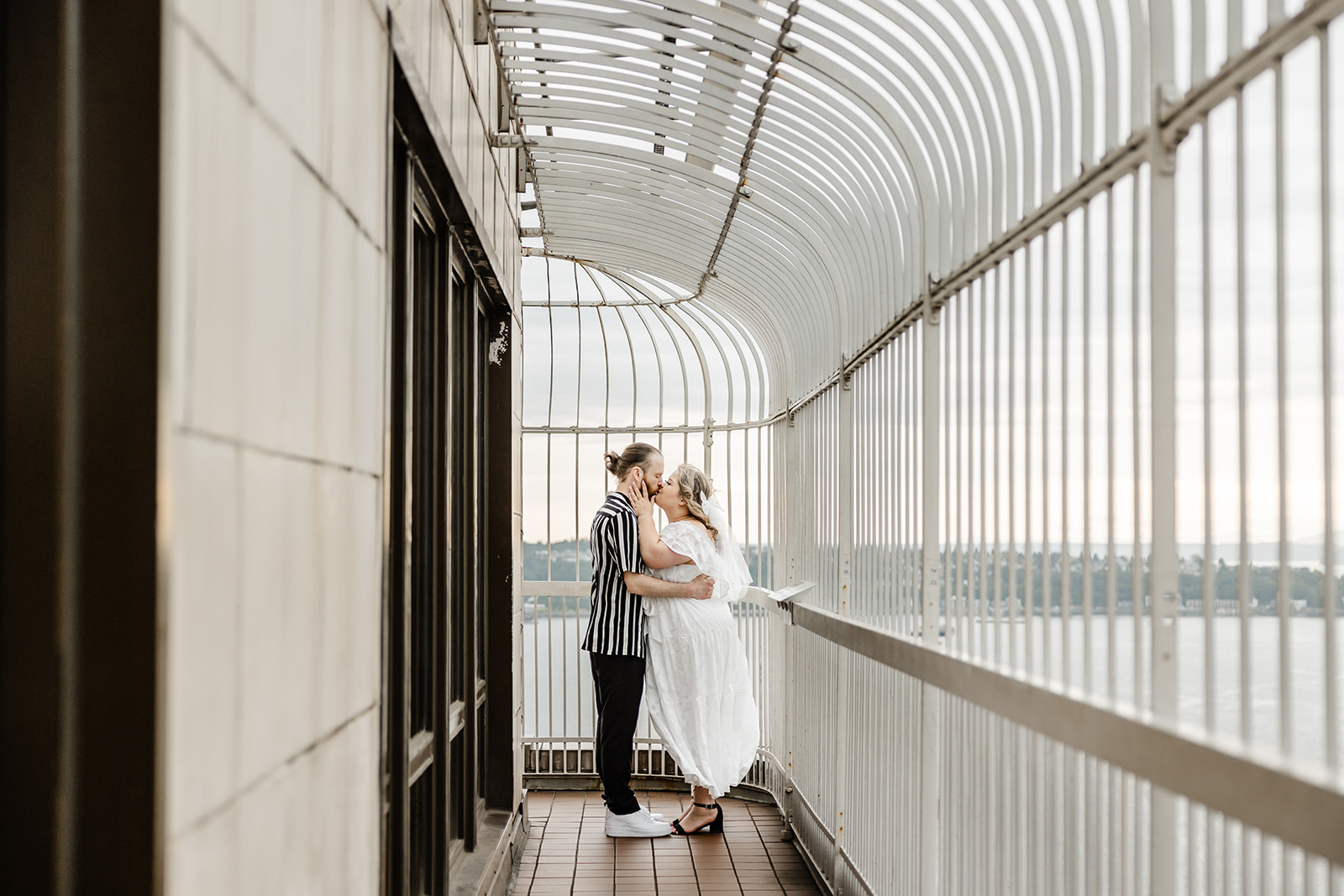 couple kisses on top of smith tower