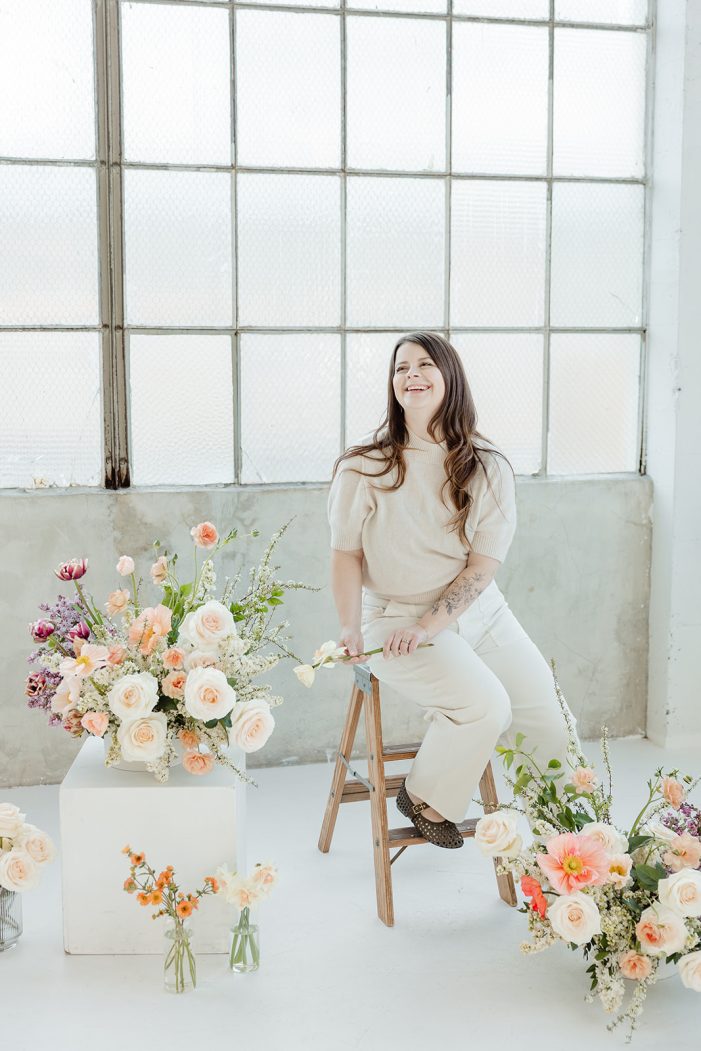man and woman pose in studio with flowers