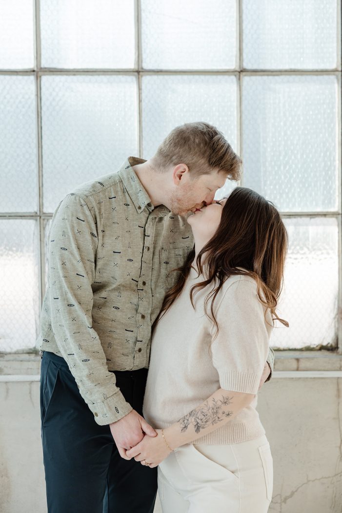 man and woman pose in studio with flowers