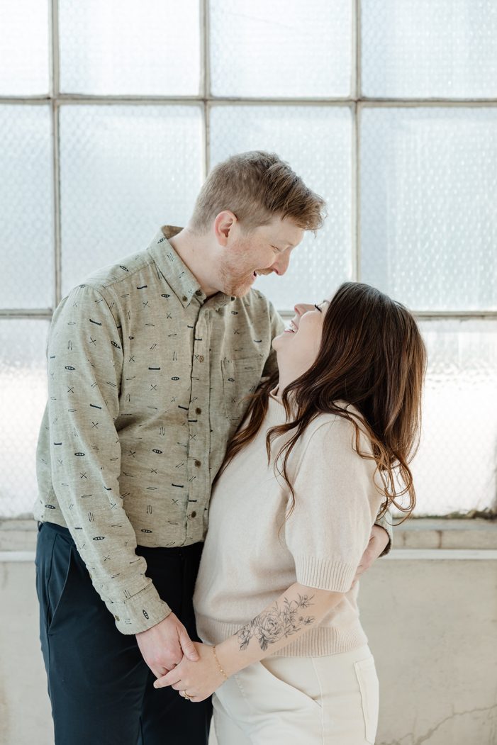 man and woman pose in studio with flowers