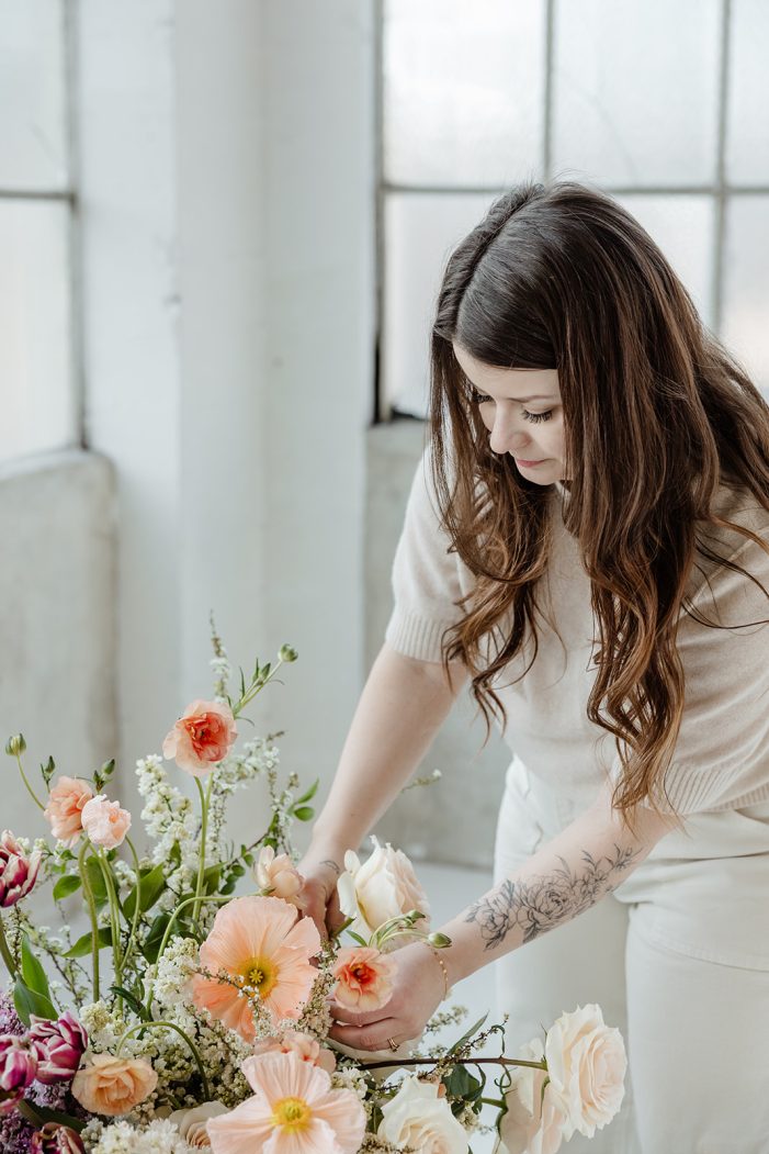 man and woman pose in studio with flowers