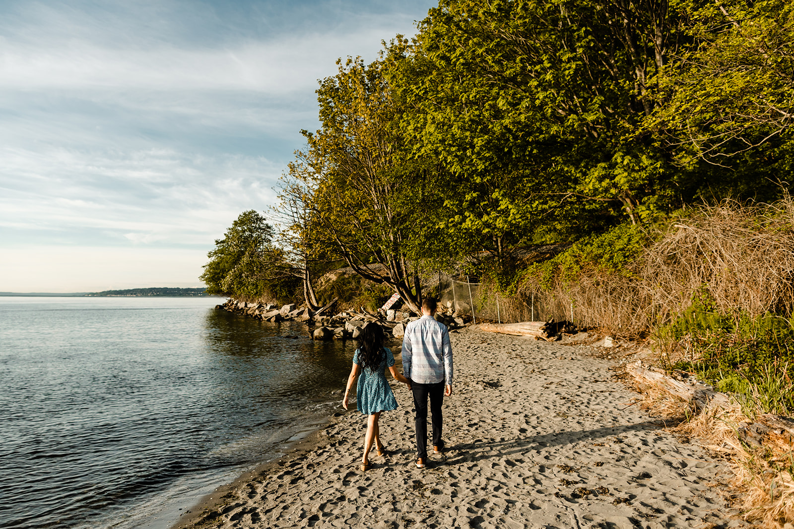 bride and groom walk down beach