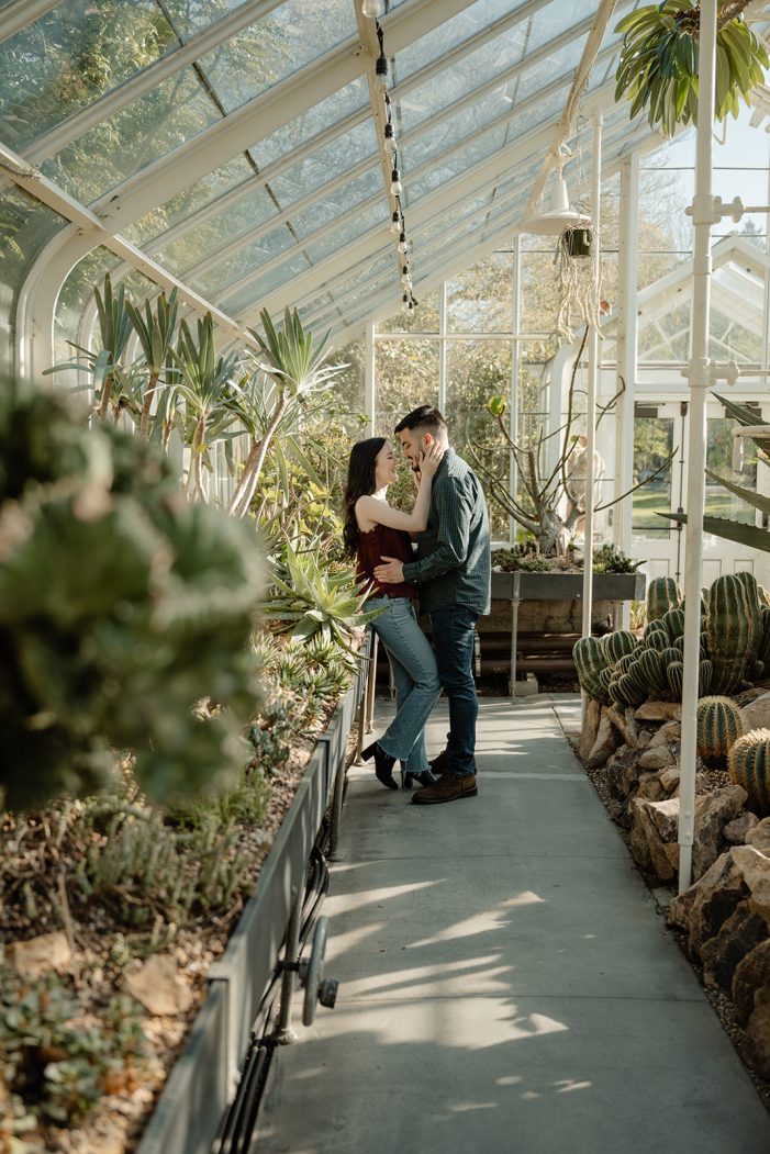 man and woman kiss in greenhouse