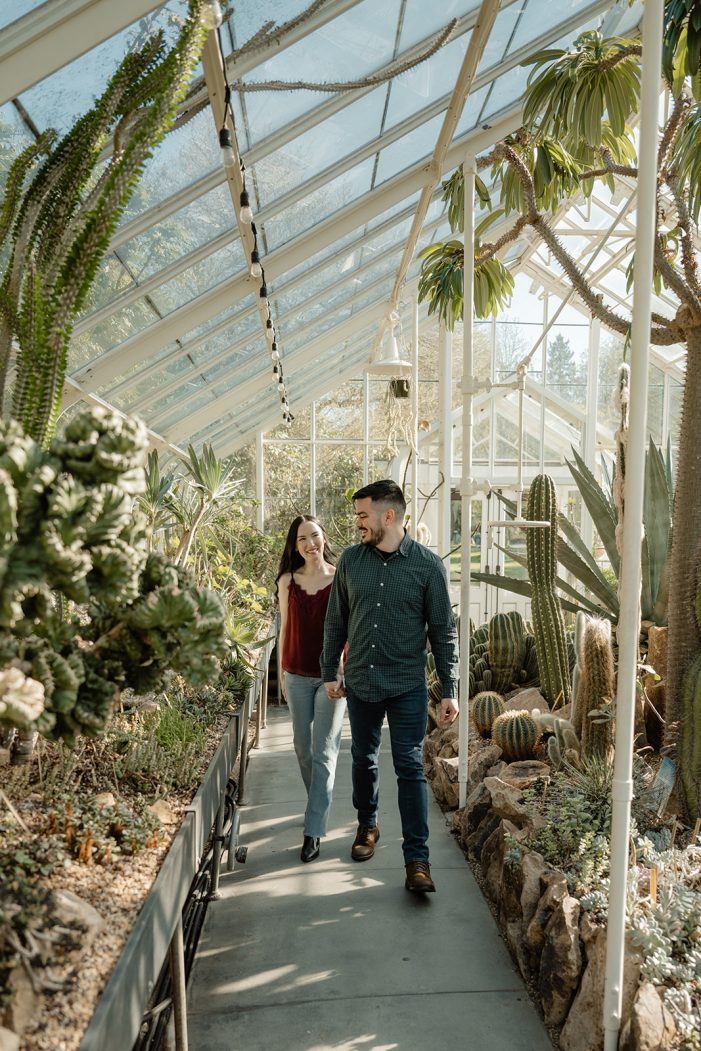 man and woman walk in greenhouse