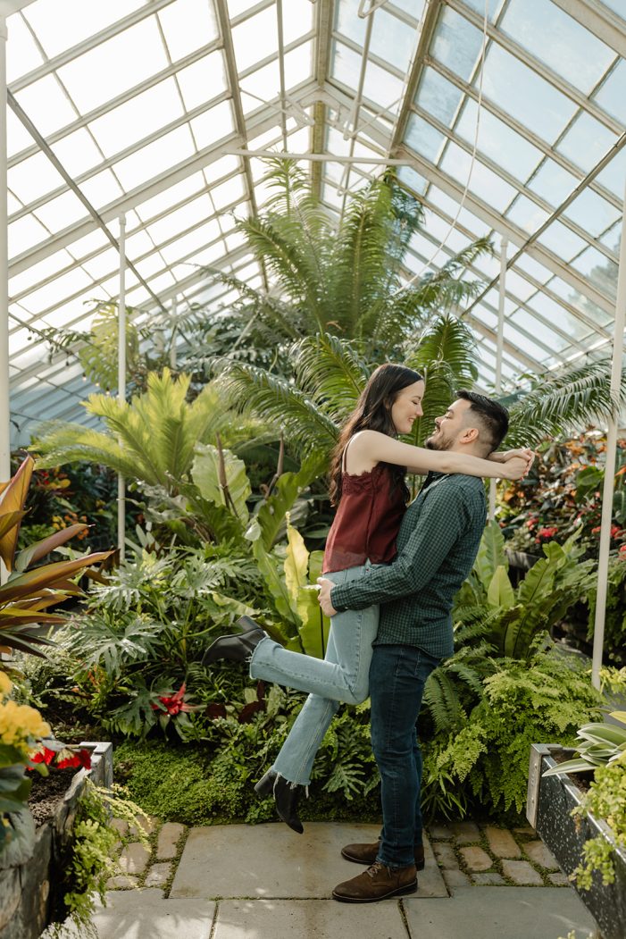 man and woman kiss in greenhouse