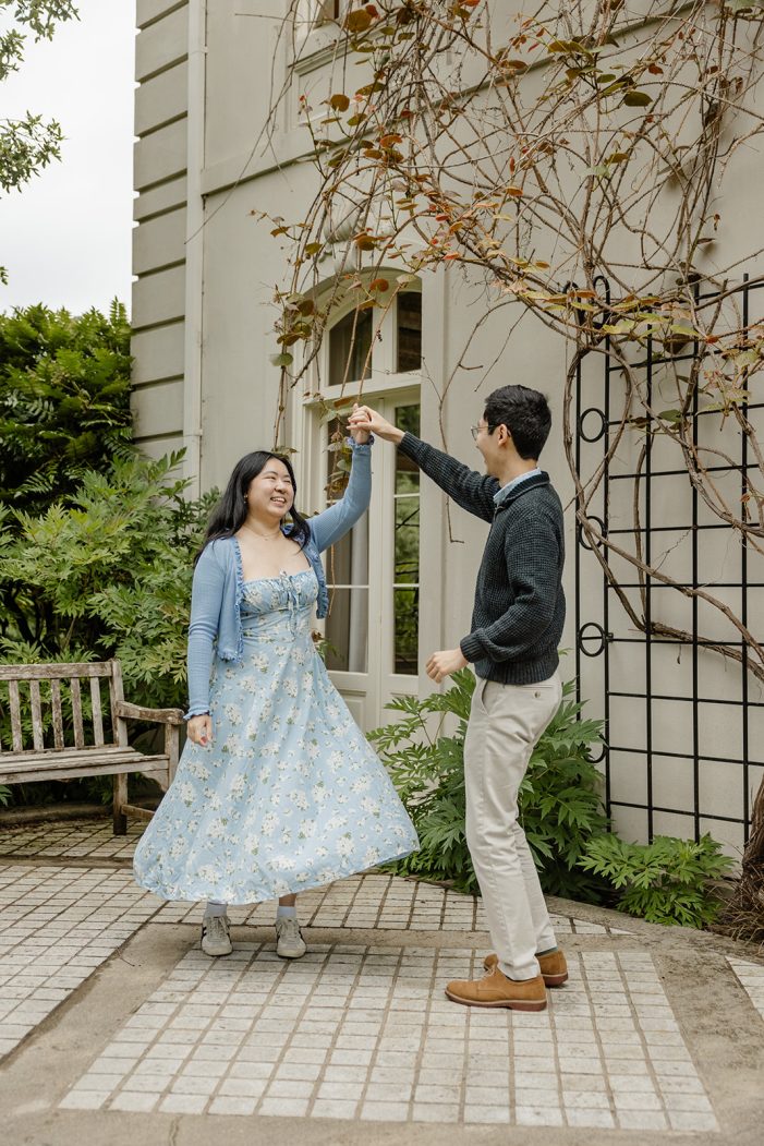 couple spins in front of building