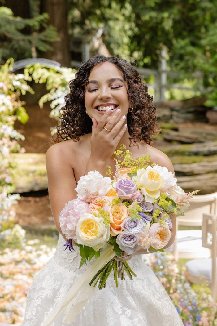 bride laughs and holds bouquet