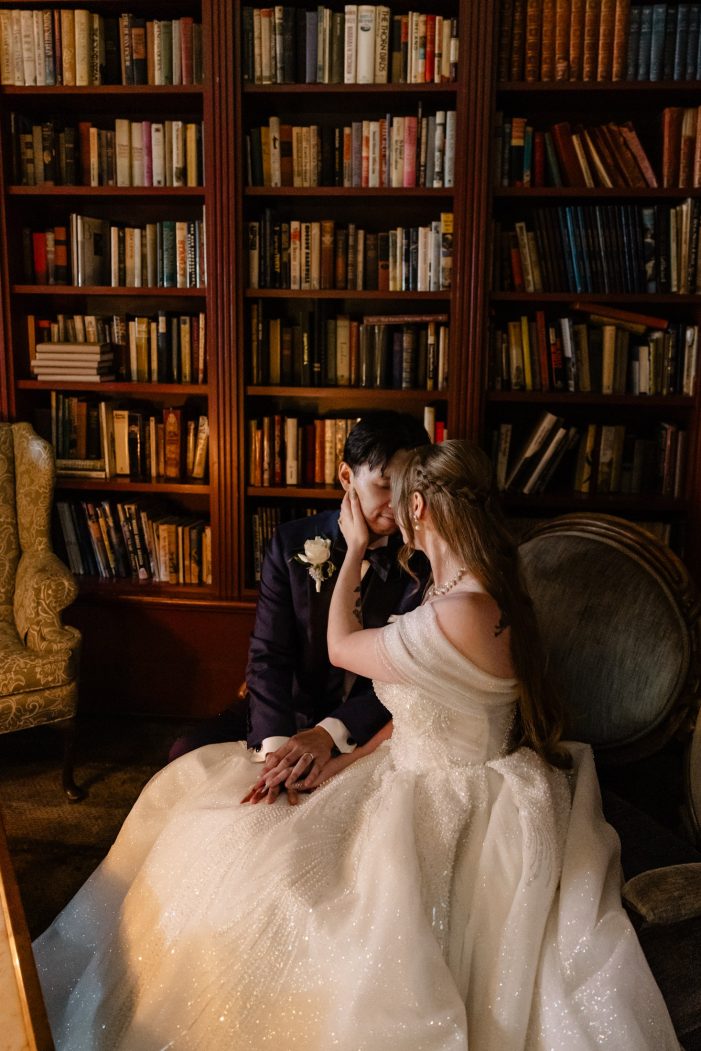 bride and groom cuddle in library