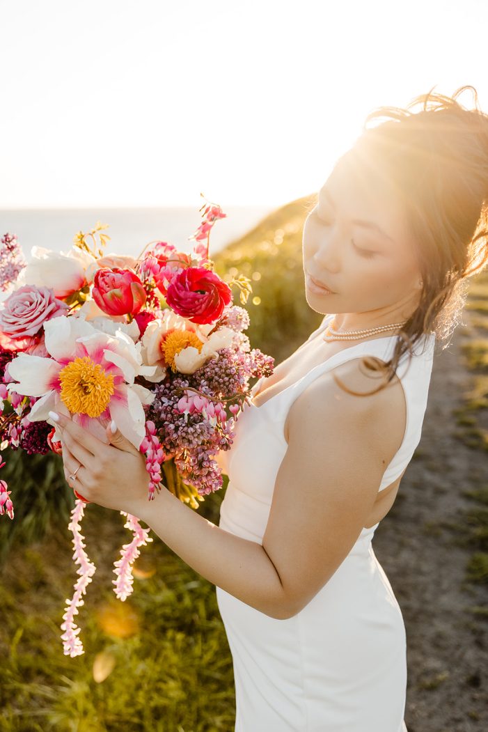 bride in the sunlight hold wildflower bouquet