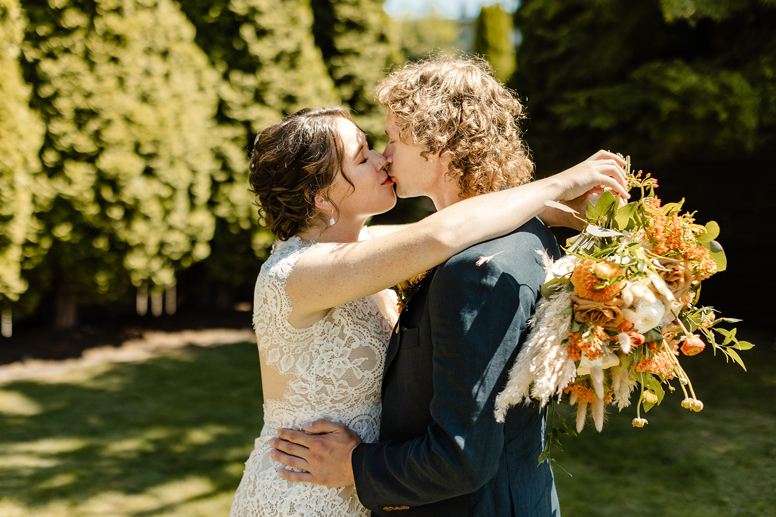 brides arms around grooms neck holding bouquet