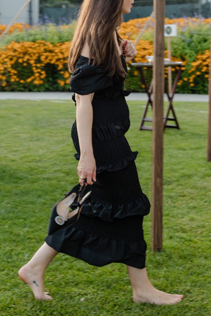 woman walks without shoes across grass