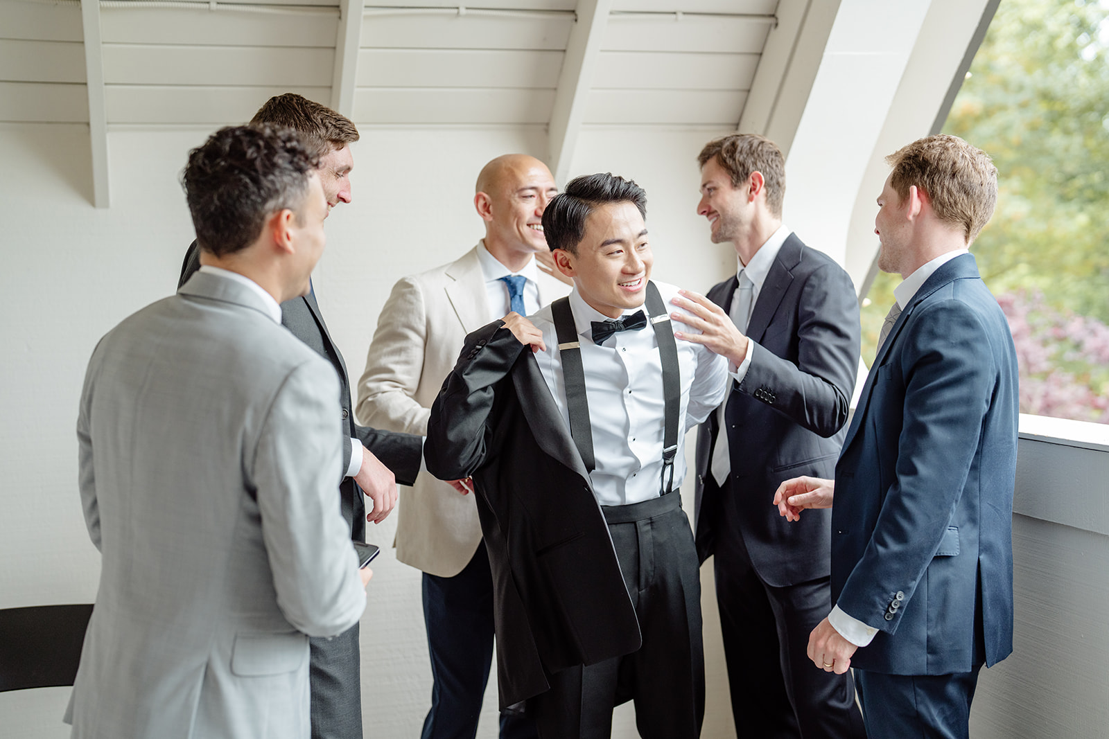 groomsmen help groom dress